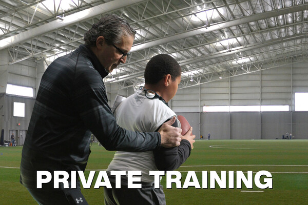 Coach Copacia instructing a young quarterback.